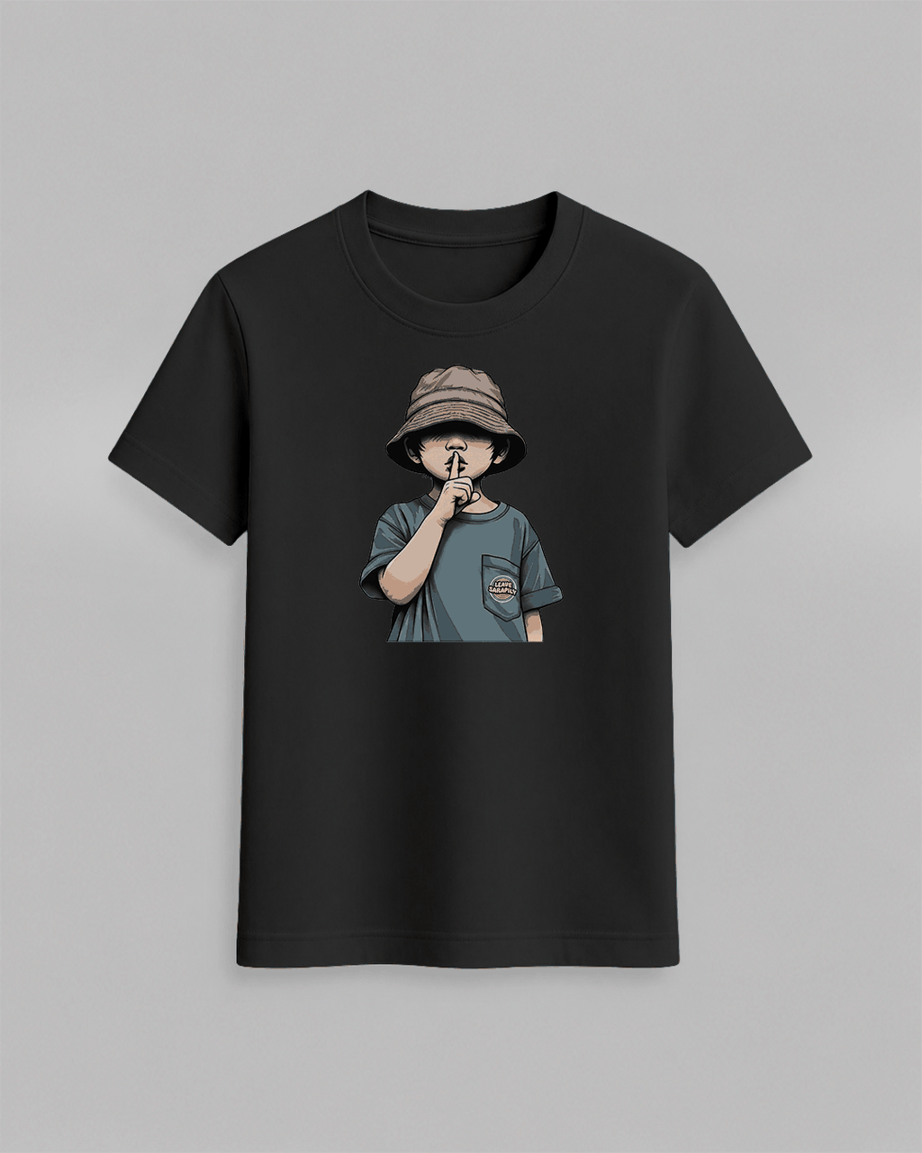 The cap boy T-Shirt in black cotton featuring a graphic of a boy wearing a bucket hat with finger on lips printed on front