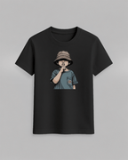 The cap boy T-Shirt in black cotton featuring a graphic of a boy wearing a bucket hat with finger on lips printed on front
