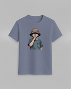 The cap boy T-Shirt in muted blue featuring a graphic of a boy wearing a brown bucket hat with finger to lips, cotton fabric